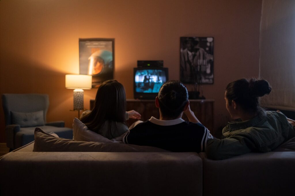 friends sitting on the couch and watching film on new year's eve