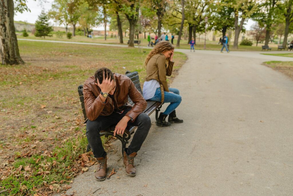 man and woman sitting on bench fighting over a breakup