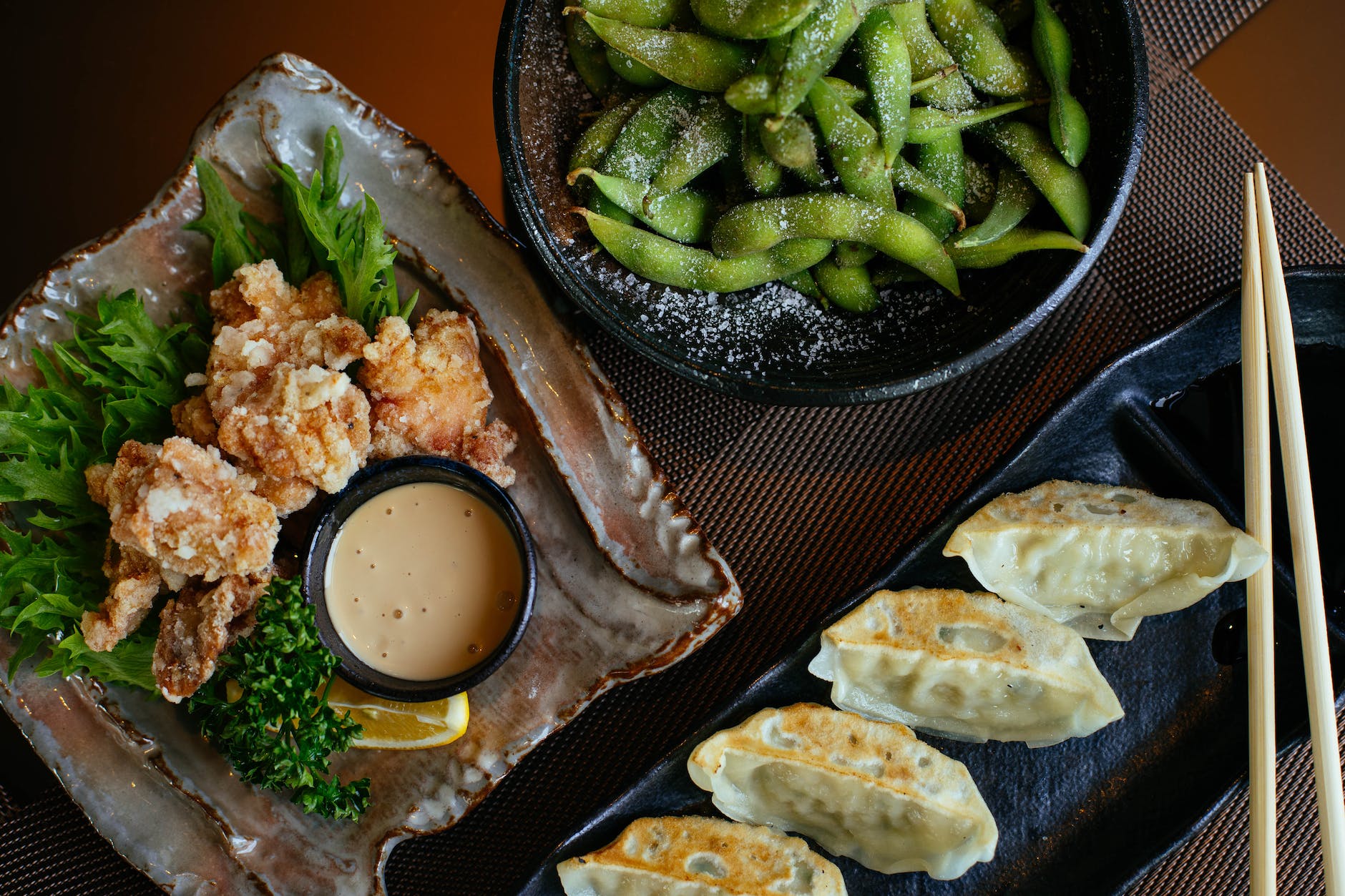 dumplings on black plate beside green beans and fried food